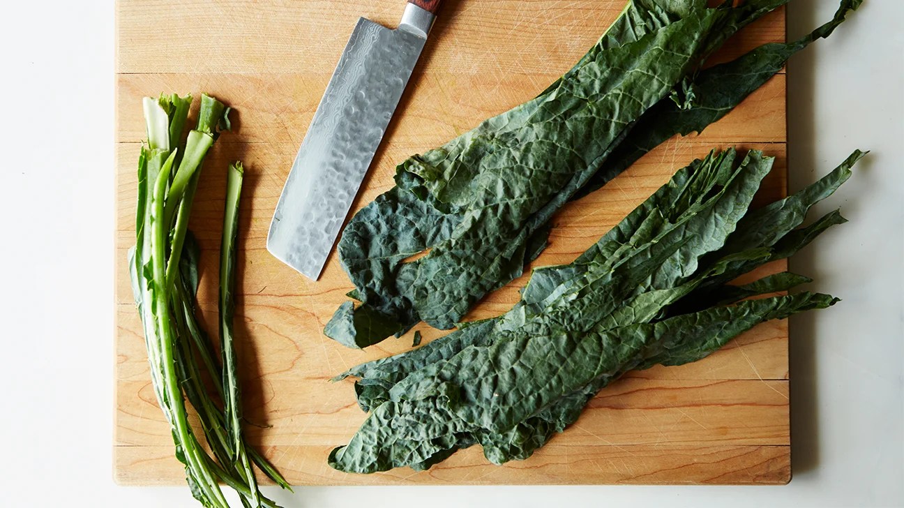 raw kale leaves on a cutting block